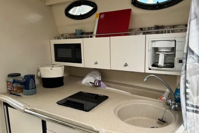 Slide: The Image of 2001 Wellcraft 330 Coastal boat kitchen with microwave, coffee maker, and sink. - 8