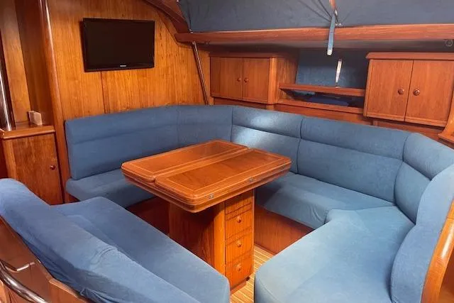 Slide: The Image of Interior of 2002 Jeanneau Sun Odyssey 45.2 yacht with blue seating and wooden table. - 12