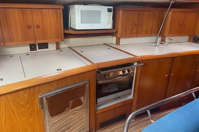 Slide: The Image of Interior of 2002 Jeanneau Sun Odyssey 45.2 yacht kitchen with wooden cabinets and appliances. - 19