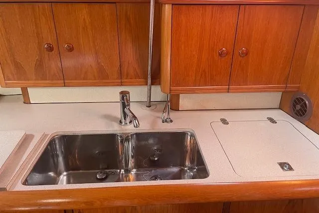 Slide: The Image of Jeanneau Sun Odyssey 45.2 2002 yacht kitchen with double sink and wooden cabinets. - 20