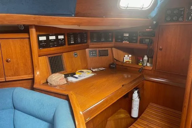 Slide: The Image of Navigation station of 2002 Jeanneau Sun Odyssey 45.2 sailboat with wooden interior and control panels. - 24