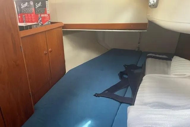 Slide: The Image of Interior cabin of 2002 Jeanneau Sun Odyssey 45.2 with blue bedding and storage. - 27