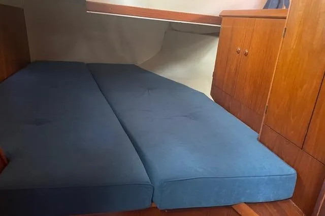 Slide: The Image of Cabin interior of 2002 Jeanneau Sun Odyssey 45.2 with blue cushions and wooden cabinetry. - 28