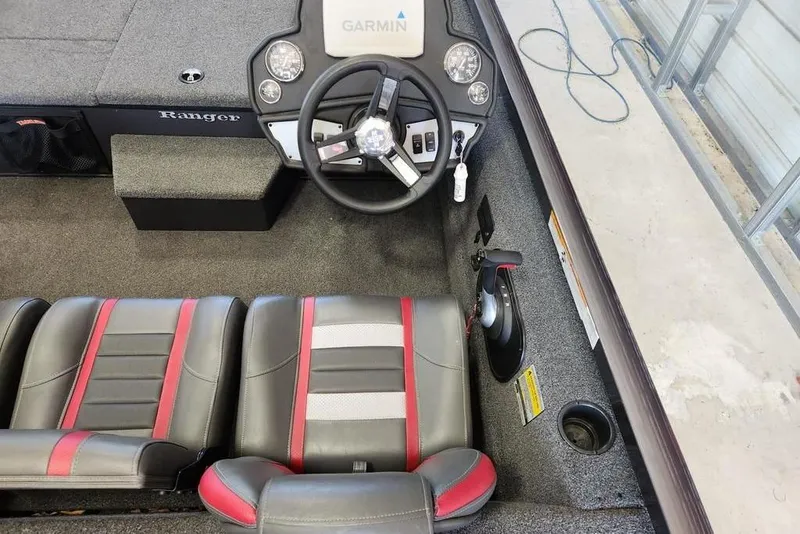 Slide: The Image of 2006 Sea Hunt Escape 200 boat interior with cushioned seating in a garage setting. - 7