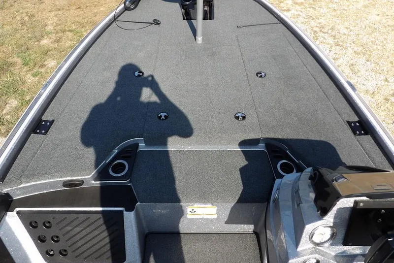 Slide: The Image of 2023 Nitro Z19 boat deck with shadow, featuring carpeted surface and cup holders. - 21