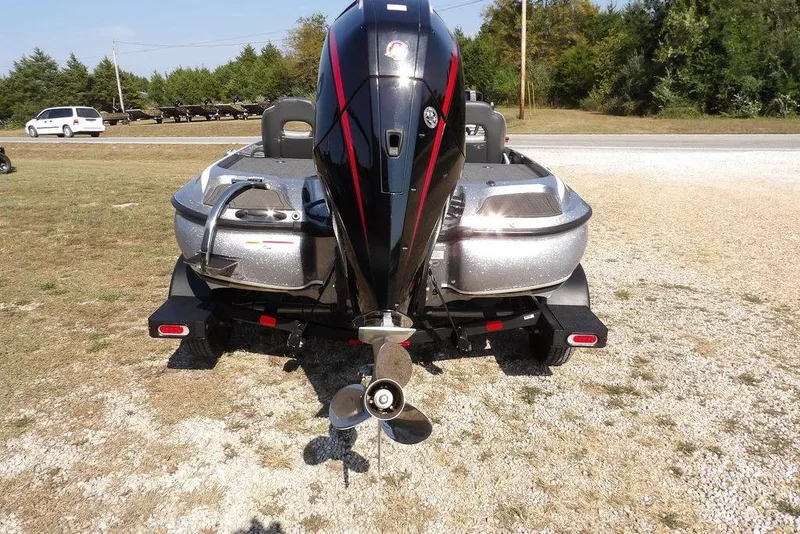 Slide: The Image of 2023 Nitro Z19 boat with powerful outboard motor, parked on gravel near road. - 8