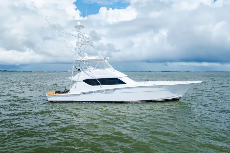 Slide: The Image of 2005 Hatteras Convertible 60 yacht on open water under cloudy sky. - 1