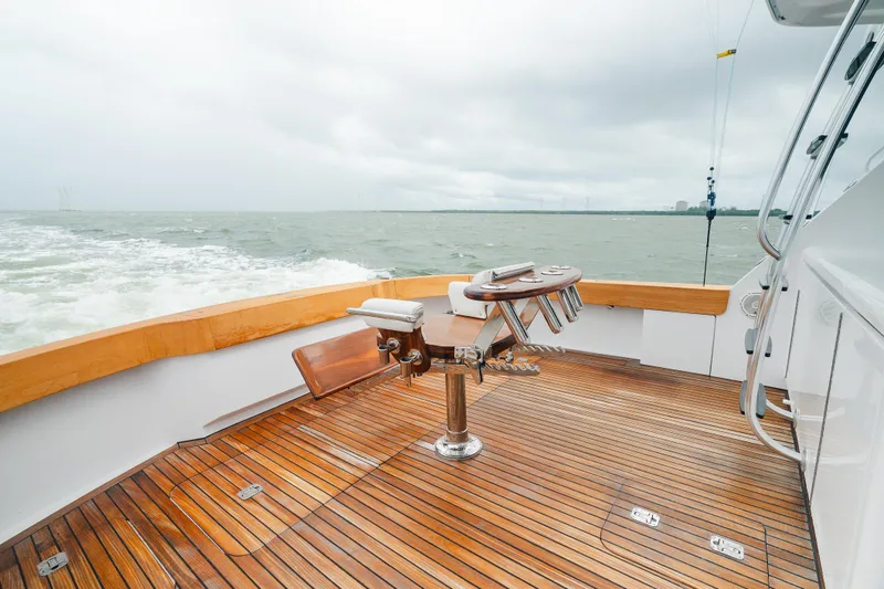 Slide: The Image of 2005 Hatteras Convertible 60 yacht deck with fishing chair, wooden flooring, and ocean view. - 11