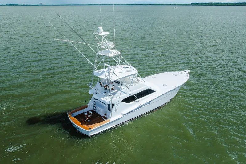Slide: The Image of 2005 Hatteras Convertible 60 yacht cruising on open water, aerial view. - 2