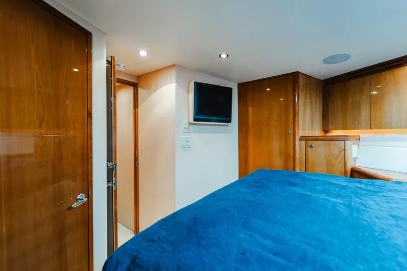 Slide: The Image of Luxurious cabin interior of 2005 Hatteras Convertible 60 yacht with wood paneling and blue bedding. - 29