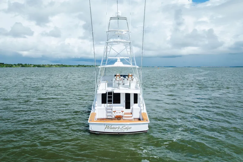 Slide: The Image of 2005 Hatteras Convertible 60 yacht on open water under cloudy sky. - 3