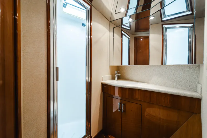 Slide: The Image of Luxurious bathroom in 2005 Hatteras Convertible 60 yacht with modern fixtures and elegant wood cabinetry. - 30
