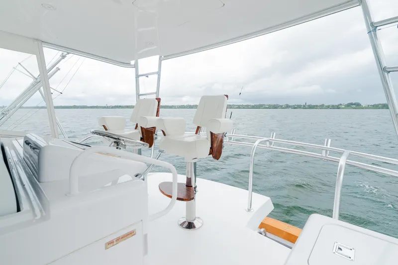 Slide: The Image of 2005 Hatteras Convertible 60 yacht interior with white seating and ocean view. - 34
