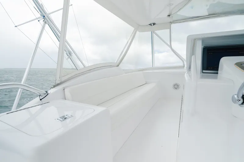 Slide: The Image of 2005 Hatteras Convertible 60 yacht interior with white seating and ocean view. - 39