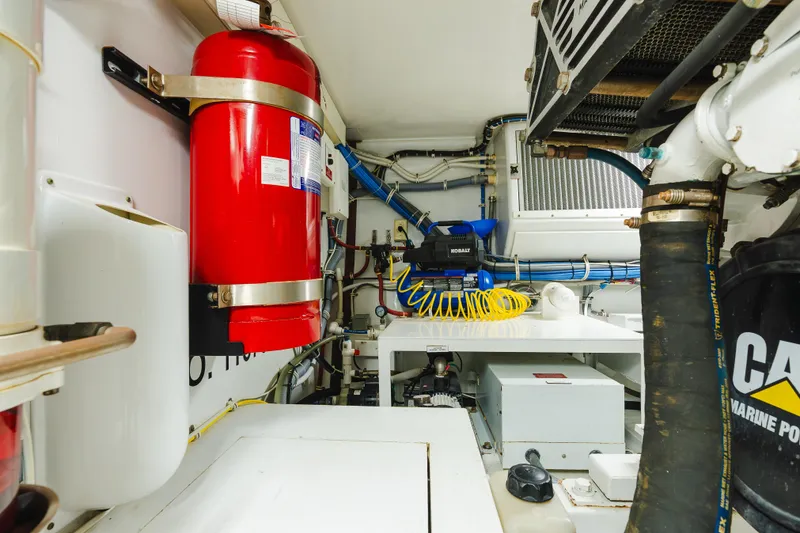Slide: The Image of Engine room of 2005 Hatteras Convertible 60 yacht with fire extinguisher and equipment. - 46