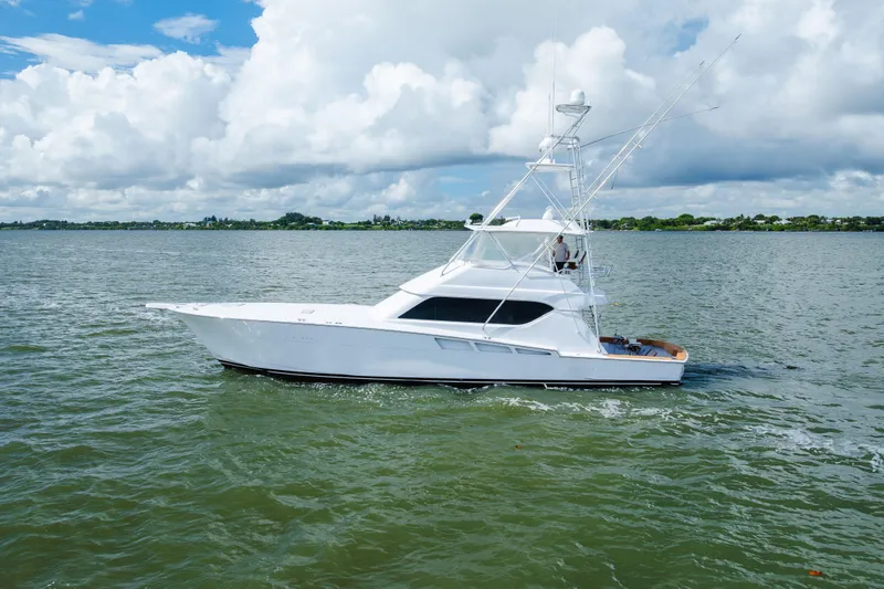 Slide: The Image of 2005 Hatteras Convertible 60 yacht cruising on a calm, scenic waterway. - 5