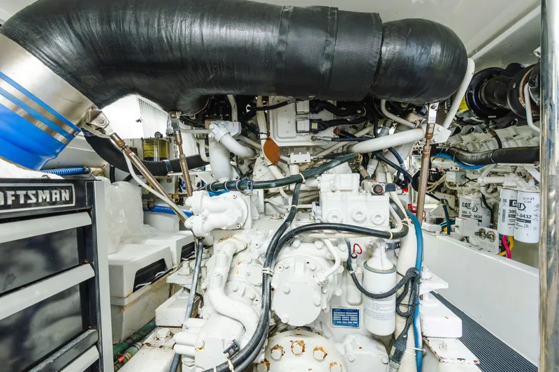 Slide: The Image of Engine room of 2005 Hatteras Convertible 60 yacht, showcasing complex machinery and components. - 51