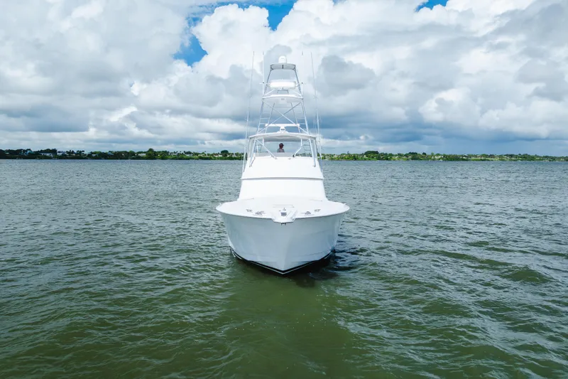Slide: The Image of 2005 Hatteras Convertible 60 yacht on open water under cloudy sky. - 52