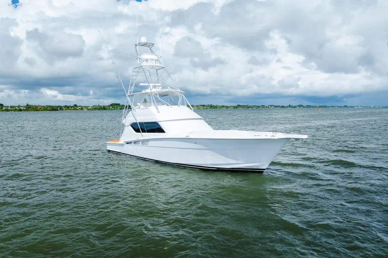 Slide: The Image of 2005 Hatteras Convertible 60 yacht on open water under cloudy sky. - 53
