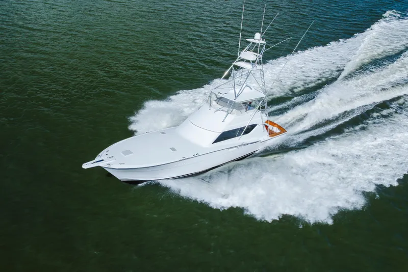 Slide: The Image of 2005 Hatteras Convertible 60 yacht cruising on open water, creating a dynamic wake. - 62