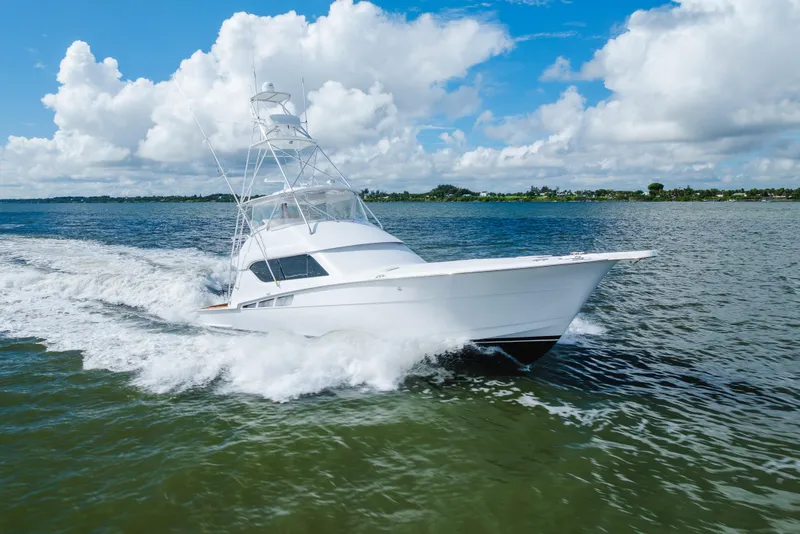 Slide: The Image of 2005 Hatteras Convertible 60 yacht cruising on open water under a blue sky. - 65
