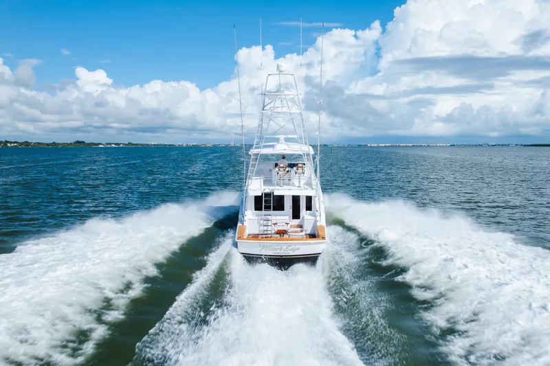Slide: The Image of 2005 Hatteras Convertible 60 yacht cruising on open water under a blue sky. - 67