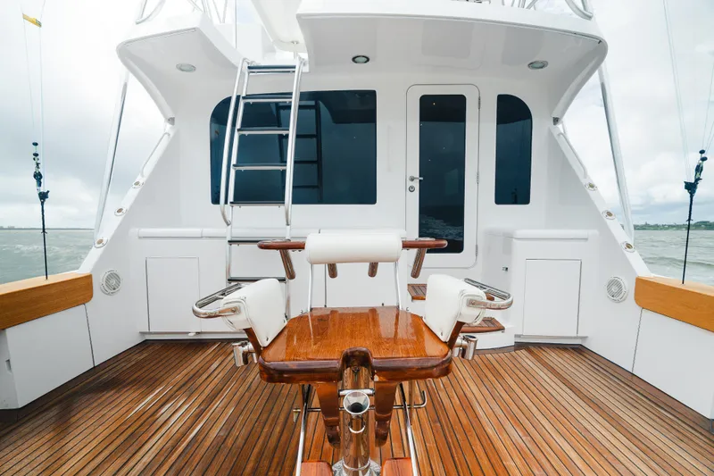 Slide: The Image of 2005 Hatteras Convertible 60 yacht deck with wooden flooring and fishing chair. - 7