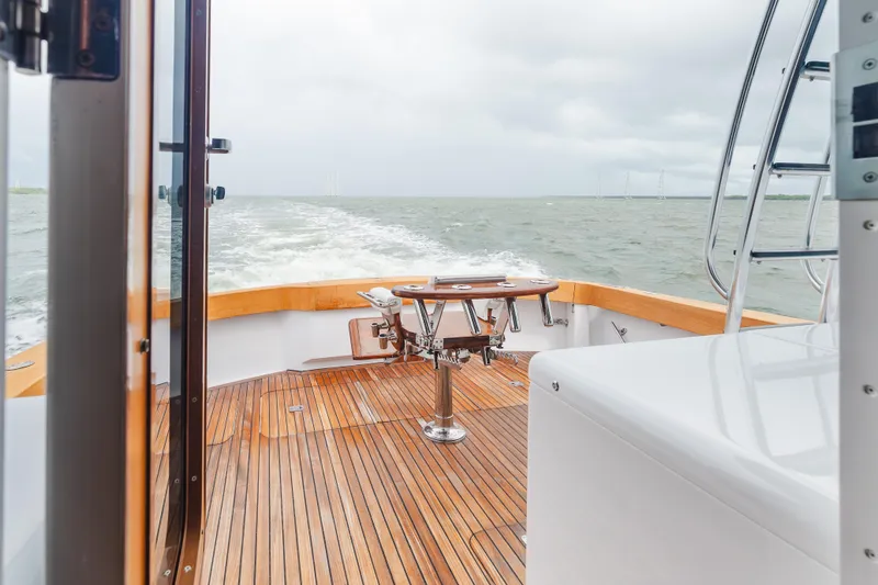 Slide: The Image of 2005 Hatteras Convertible 60 yacht deck with wooden flooring and ocean view. - 9