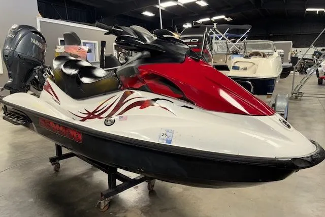 The Image of 2008 Sea-Doo GTI SE 130 jet ski with red and white design in a showroom. - 1