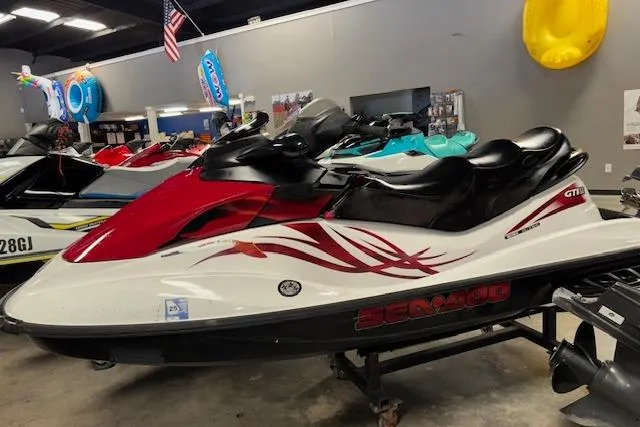 Slide: The Image of 2008 Sea-Doo GTI SE 130 jet ski in showroom, red and white design. - 3