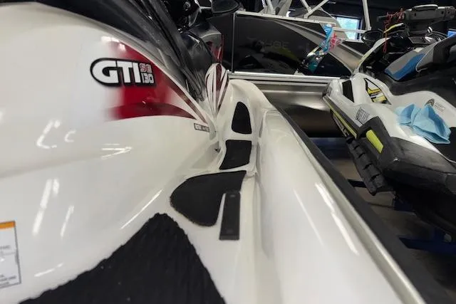 Slide: The Image of 2008 Sea-Doo GTI SE 130 jet ski, white with red accents, in showroom. - 8