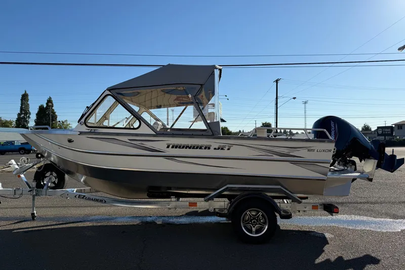 Slide: The Image of 2026 Thunder Jet 185 Luxor boat on trailer, side view under clear sky. - 4