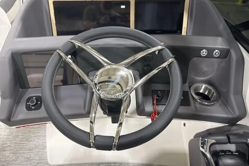 Slide: The Image of Steering wheel of 2025 Bennington 27QXSBWAT2 boat, featuring modern dashboard controls. - 7
