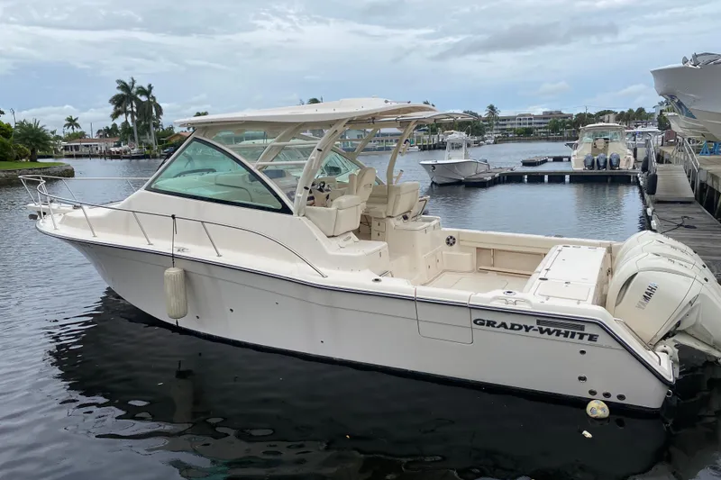 The Image of 2022 Grady-White Express 370 boat docked in a marina, featuring sleek design and Yamaha engines. - 0