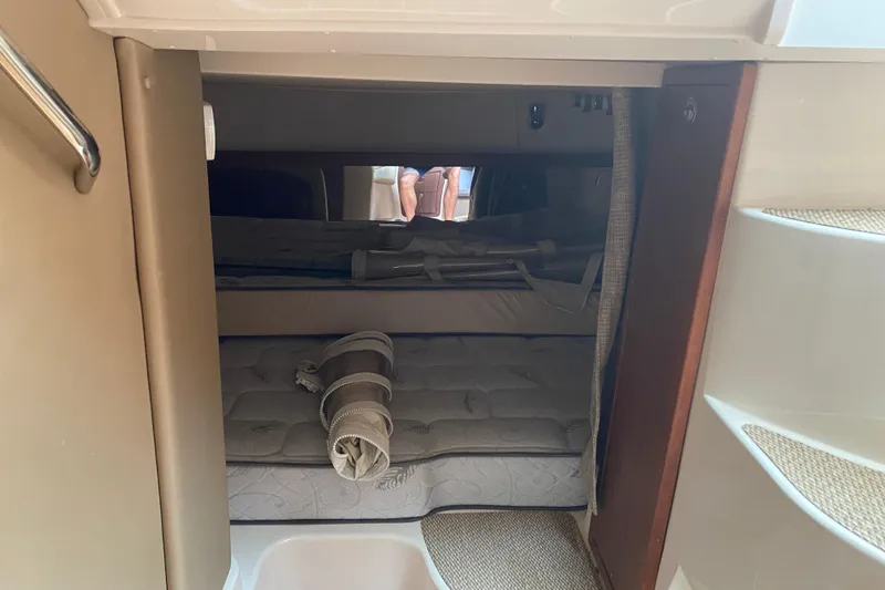 Slide: The Image of 2022 Grady-White Express 370 cabin interior with cozy sleeping area and rolled bedding. - 16