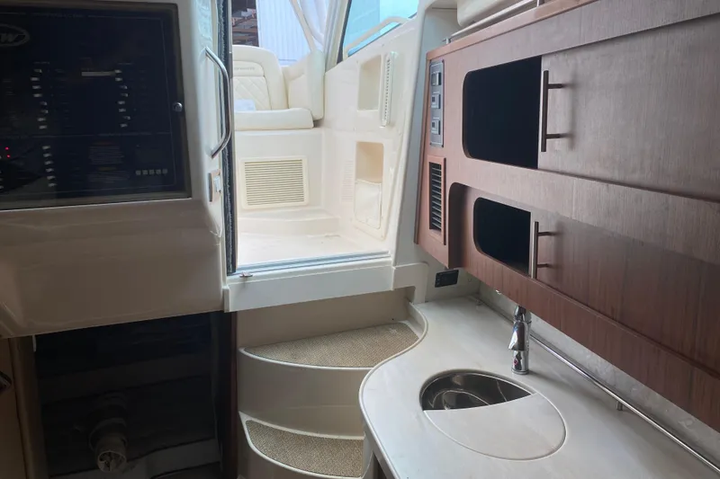 Slide: The Image of Interior of 2022 Grady-White Express 370 boat, featuring a compact kitchenette and seating area. - 17