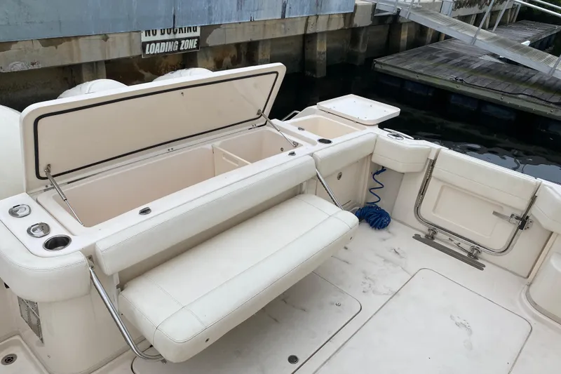 Slide: The Image of 2022 Grady-White Express 370 boat interior with open storage and seating at dock. - 18