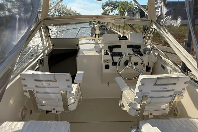 Slide: The Image of Interior of a 2005 Carolina Classic 25 boat with steering wheel and seating. - 12