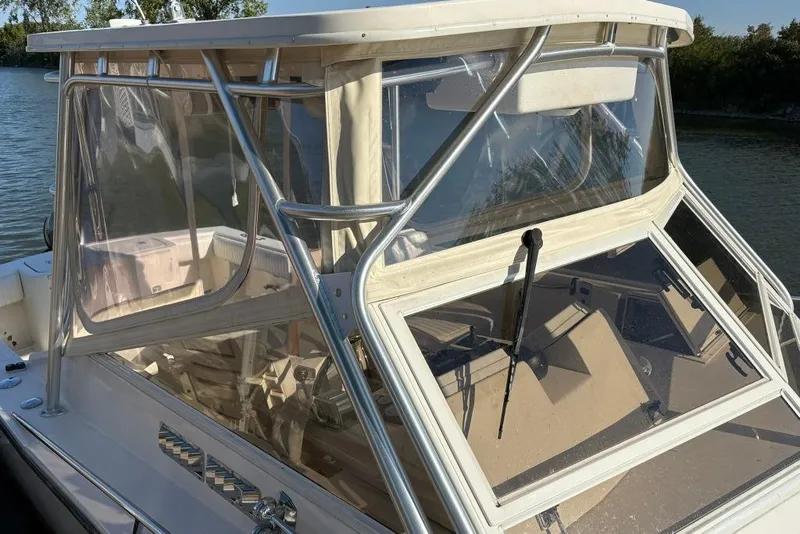 Slide: The Image of 2005 Carolina Classic 25 boat with clear windshield and sturdy frame on calm water. - 3