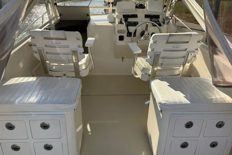 Slide: The Image of Interior of a 2005 Carolina Classic 25 boat with white seating and steering area. - 5
