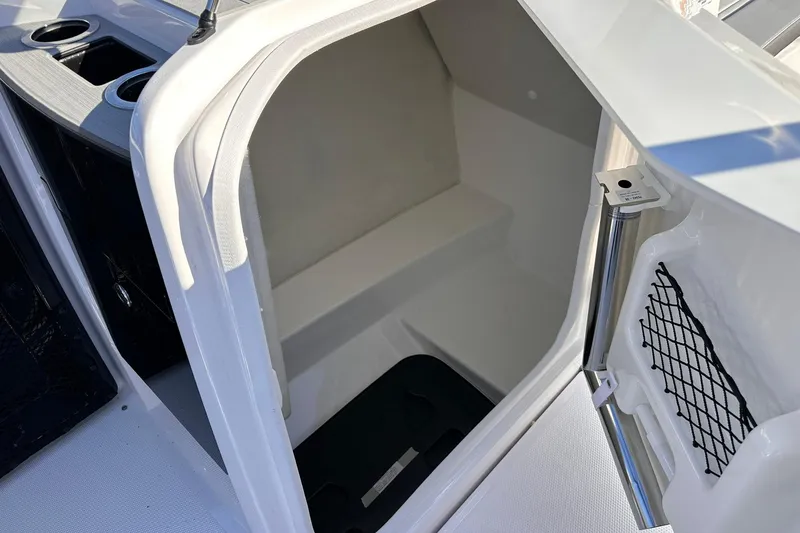 Slide: The Image of Interior storage compartment of 2025 Yamaha Boats AR250, featuring cup holders and netted storage. - 12