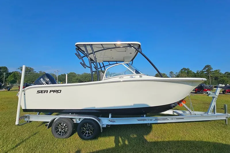 The Image of 2026 Sea Pro 240 Dual Console Sport boat on trailer, displayed outdoors under clear blue sky. - 1