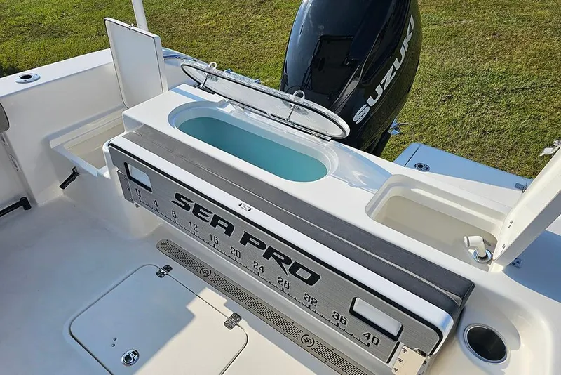Slide: The Image of 2026 Sea Pro 240 Dual Console Sport boat with Suzuki engine, featuring a livewell and storage compartments. - 13