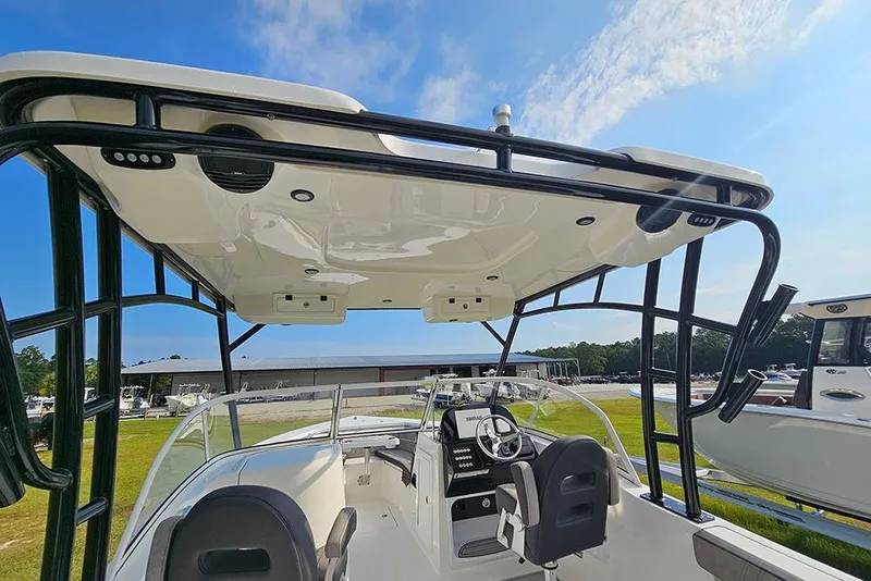 Slide: The Image of 2026 Sea Pro 240 Dual Console Sport boat interior with helm and seating under a clear sky. - 37