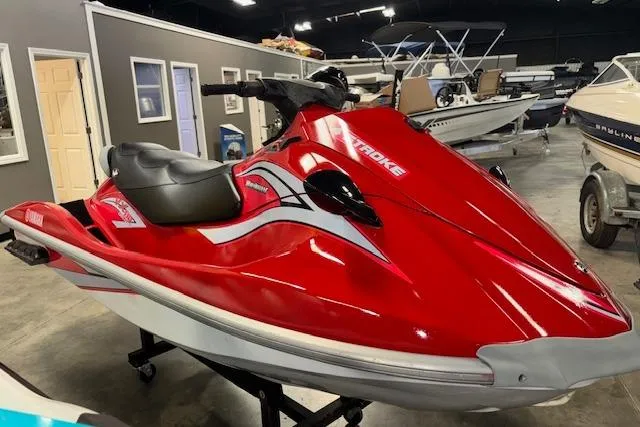 The Image of Red 2005 Yamaha WaveRunner VX 110 Deluxe jet ski in showroom, side view. - 1