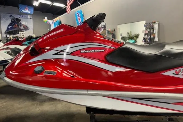 Slide: The Image of 2005 Yamaha WaveRunner VX 110 Deluxe, red and white jet ski in showroom. - 4