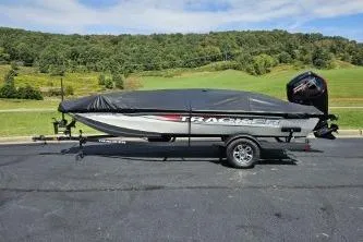 Slide: The Image of 2025 Tracker Pro Team 190 TX Tournament Edition boat on trailer, covered, scenic background. - 10