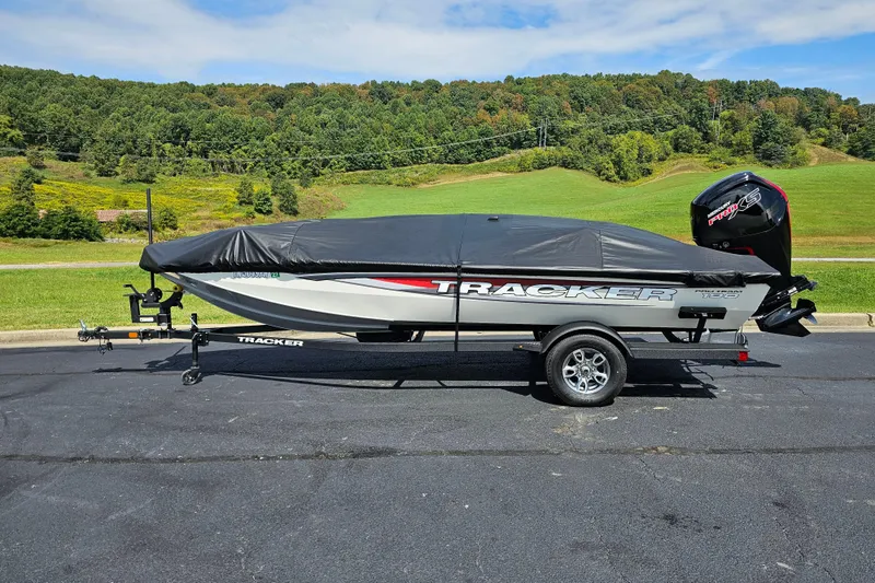 Slide: The Image of 2025 Tracker Pro Team 190 TX Tournament Edition boat on trailer, covered, scenic background. - 11