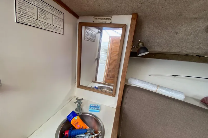 Slide: The Image of Interior of 1989 Blackfin 27 Fisherman boat with sink, mirror, and storage area. - 15