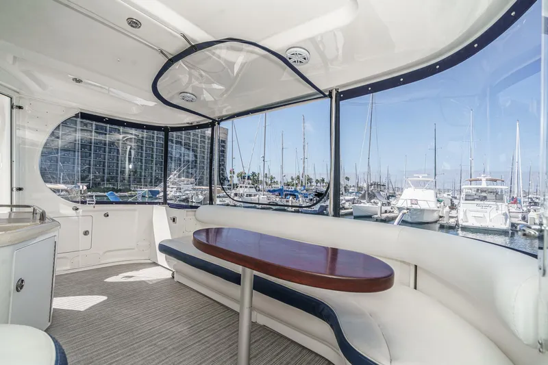 Slide: The Image of 2005 Sea Ray 390 Motor Yacht interior with marina view, featuring elegant seating and table. - 11
